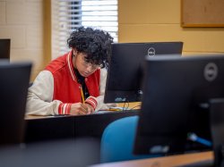 Student studying on their computer in the library.