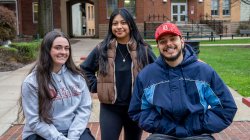 Three students smiling at the camera.