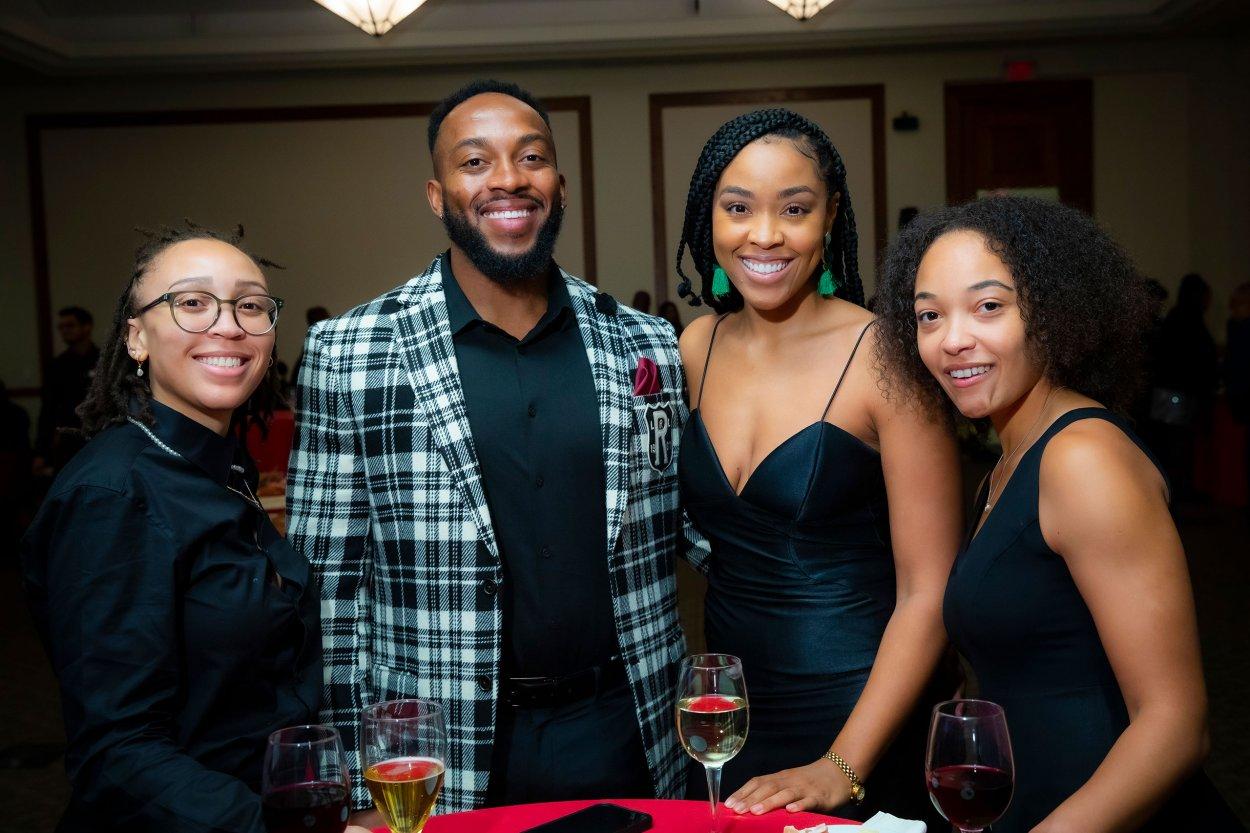 Group of four people smiling at the camera.